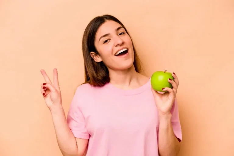 בחורה צעירה שמחה אוכלת תפוח - חילוף חומרים מהיר